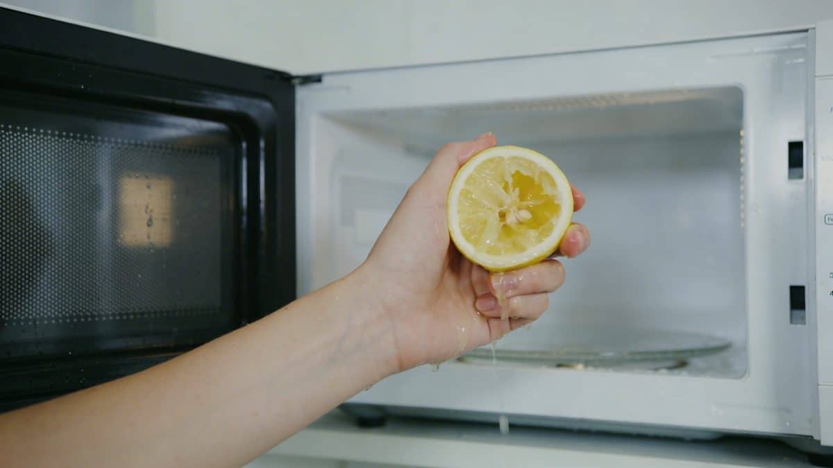 Personne nettoyant linterieur dun micro ondes avec un citron coupe