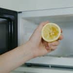 Personne nettoyant linterieur dun micro ondes avec un citron coupe