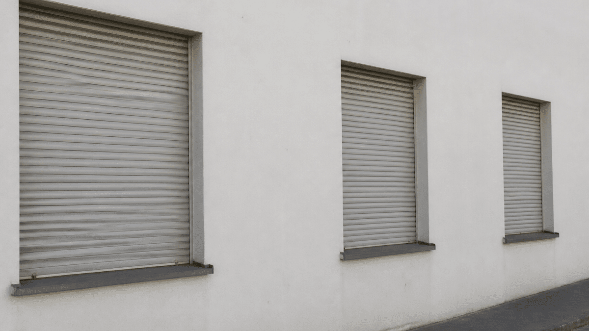 Plusieurs volets roulants fermes horizontalement sur facade blanche